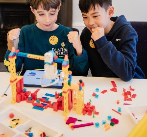Two boys celebrating their LEGO robot